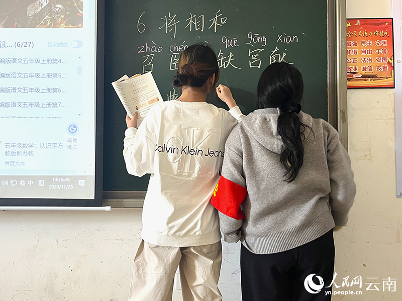 2影子老师（右）陪同学生一同上台回答问题。人民网-尹馨摄