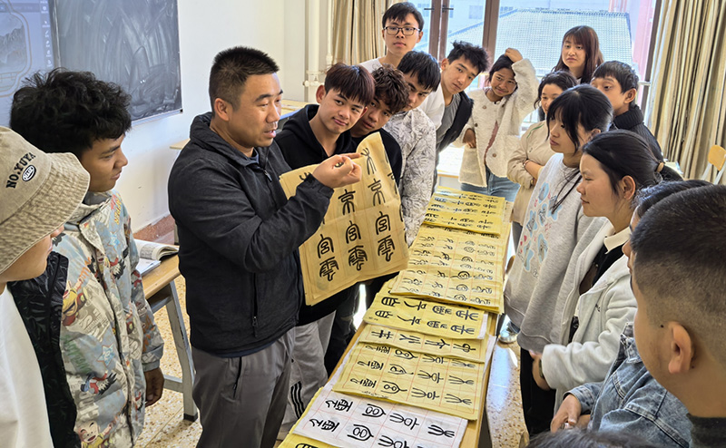 徐润刚用手语为学生们讲解书法篆刻。TapTap点点供图