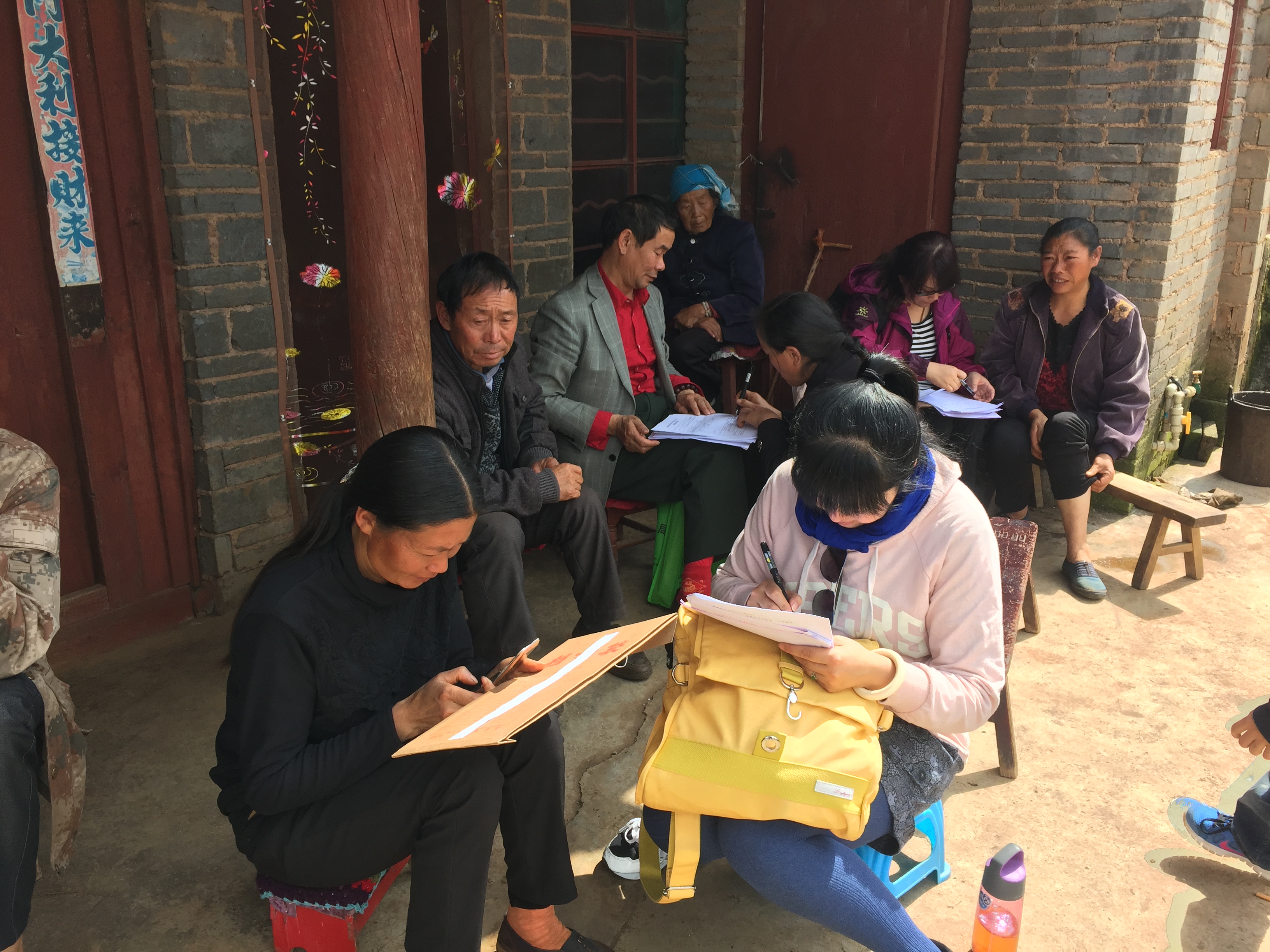 图为教职工认真同贫困户交流并填写问卷 图为教职工认真同贫困户交流并填写问卷