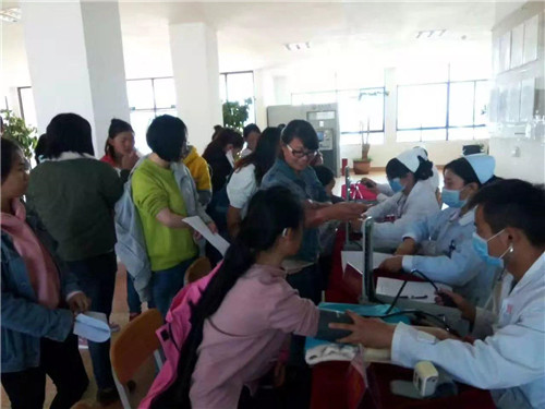 图为学生在大厅领取体检表 